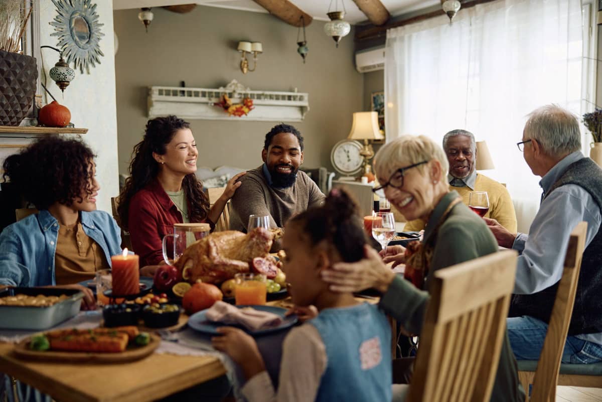 A big group smiling around the dinner table