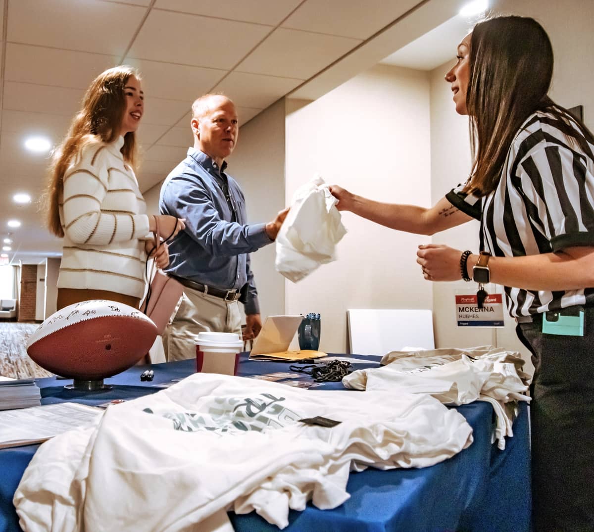 A man and woman receiving swag from a woman