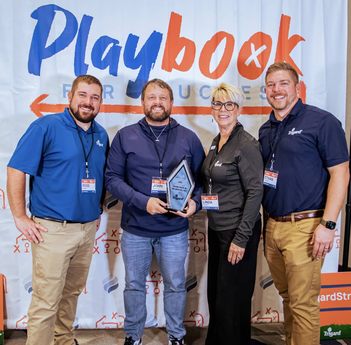 4 people holding a plaque