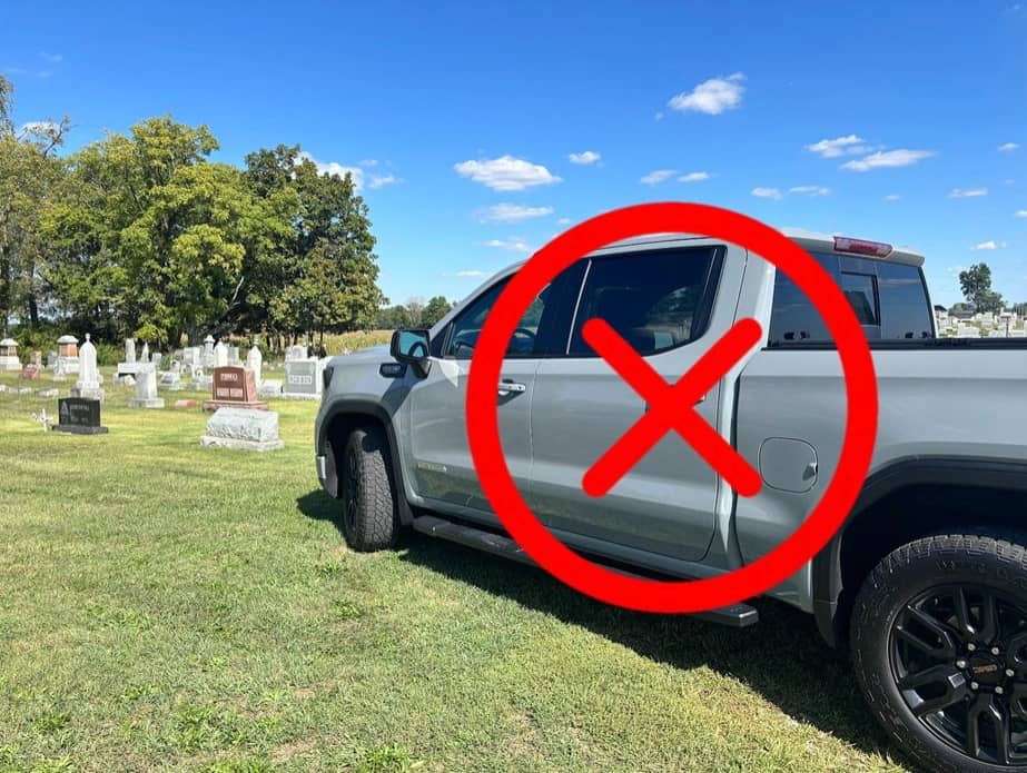 A truck on the cemetery grass with a circle and X around it
