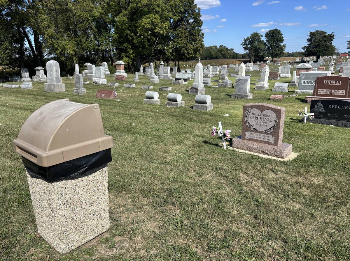 A cemetery with a trash can